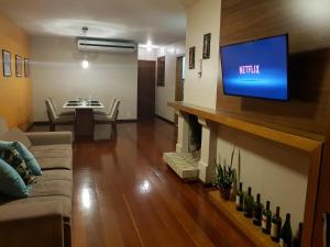 a living room with a flat screen tv on a wall at GringsApsAluguel205 in Gramado