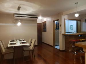 uma sala de jantar com mesa e cadeiras e uma cozinha em GringsApsAluguel205 em Gramado