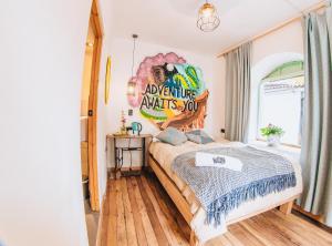 a bedroom with a bed with a mural on the wall at Supertramp Hostel Cusco in Cusco