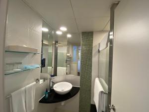 Baño blanco con lavabo y espejo en Holiday Inn Express Hong Kong Causeway Bay, an IHG Hotel, en Hong Kong