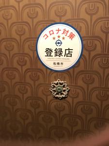 a sign hanging on a wall with a pattern at Family Resort Apartment in Funabashi