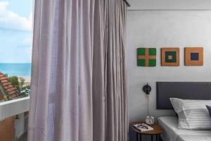 Schlafzimmer mit einem Bett und einem Fenster mit Aussicht in der Unterkunft HY Beach Flats - Fernando Pessoa in Recife