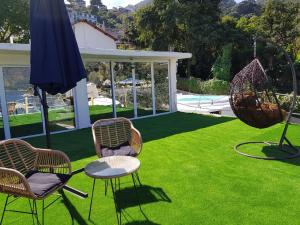 a lawn with chairs and a table and an umbrella at DUBAI by luxury Atitlan in San Pedro La Laguna
