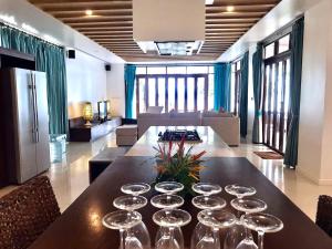 a dining room with a table with wine glasses on it at Amatapura Beachfront Villa 14, SHA Certified in Ao Nam Mao