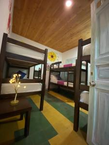 Habitación con 3 literas, mesa y puerta. en Hotel boutique stay la 10 en Medellín