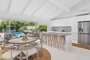 an open kitchen and dining room with a table and chairs at Alkira in Lennox Head