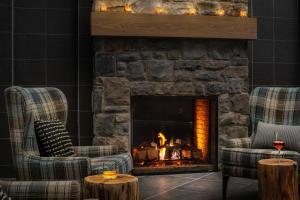a living room with a fireplace and a fire place at Saranac Waterfront Lodge in Saranac Lake