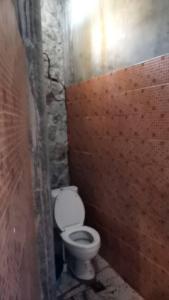 a bathroom with a white toilet in a brick wall at Farm stay 1000 Chang Valley in Ban Chak Phai