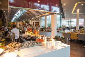 een buffet lijn met mensen die eten bereiden in een restaurant bij *BOM HOMES* FLAMINGO ĐAI LAI RESORT in Ngọc Quang