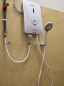 a blow dryer on the wall of a bathroom at MAIDAM Inn in Jertih