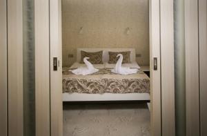 a bedroom with a bed with two swans on it at Sanatory Rassvet in Berdsk