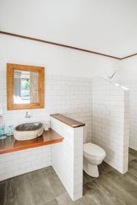 a white bathroom with a sink and a toilet at Karma Kayak in Gili Trawangan