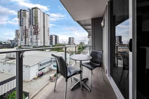 a balcony with chairs and a table and a view of a city at The Capitol Apartments in Brisbane