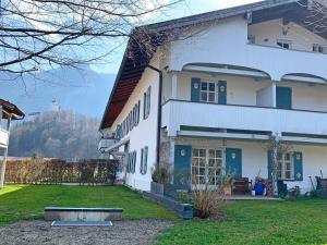 Casa blanca con puertas azules y patio en Ferienwohnung Das Lissi, en Aschau im Chiemgau