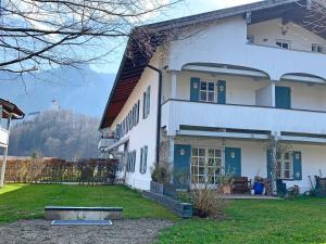 a white house with blue doors and a yard at Ferienwohnung Das Lissi in Aschau im Chiemgau