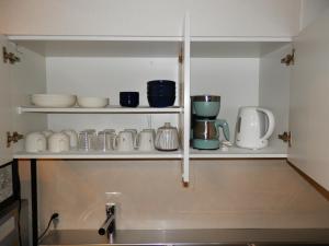 a kitchen shelf with cups and appliances on it at Maple Sumikawa #202 in Sapporo