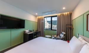 a hotel room with a large bed and a desk at Brown Dot Hotel Deokcheon in Busan