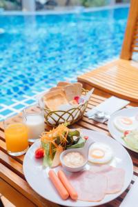 una mesa con un plato de comida junto a una piscina en Treescape Resort Chiangmai, en Chiang Mai