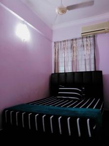 Un dormitorio con una cama negra con paredes moradas en Glory beach resort private apartment en Port Dickson