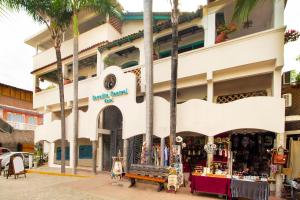 沙由利達的住宿－Sayulita Central Hotel，棕榈树建筑前的商店