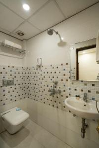 a bathroom with a toilet and a sink at HOTEL R R PALACE in Gorakhpur