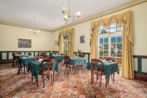 uma sala de jantar com mesas e cadeiras azuis em Orana House em Hobart