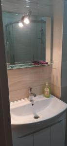lavabo blanco con espejo y lavabo en The Apartment for Comfortable Vacations in Tbilisi., en Tiflis