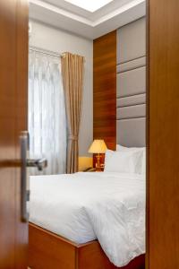 Un dormitorio con una gran cama blanca y una ventana en Anh Phát Resort, en Tĩnh Gia