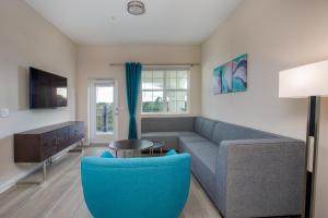- un salon avec un canapé et un fauteuil bleu dans l'établissement Vista Cay Resort by Millenium at Universal Blvd., à Orlando