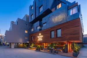 um edifício de hotel com uma fachada de madeira com plantas em The OneFive Terrace Fukuoka em Fukuoka