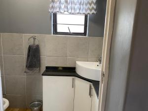 a small bathroom with a sink and a window at 59 On Gail in Ballito +10 photos