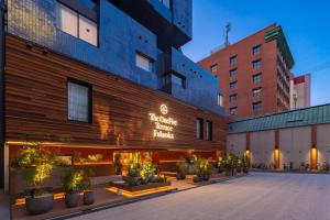 um hotel com plantas em frente a um edifício em The OneFive Terrace Fukuoka em Fukuoka