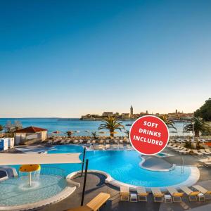 a swimming pool with a sign that reads soft drinks wanted at Valamar Padova Hotel in Rab