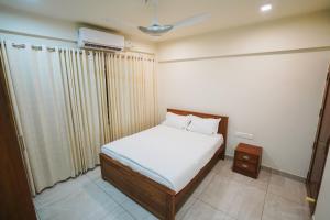a small bedroom with a bed and a air conditioner at Fortune Avenue in Mattanūr
