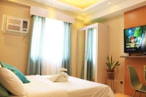 a bedroom with a bed with a swan on it at Joyful Hub with Netflix at Sunvida in Cebu City