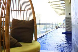a swing with a pillow in the middle of a swimming pool at Joyful Hub with Netflix at Sunvida in Cebu City