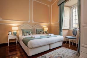 - une chambre avec un grand lit et une fenêtre dans l'établissement Casa Beny 1897 Guesthouse, à Loulé