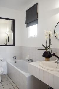 La salle de bains est pourvue d'une baignoire, de toilettes et d'un lavabo. dans l'établissement Palm Cove - 31 Akrotiri Santorini, à Ballito