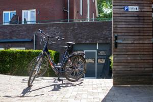 una bicicleta estacionada en una acera frente a un edificio en Heuvelrijk Berg en Dal, en Groesbeek