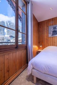 ein Schlafzimmer mit einem Bett und einem großen Fenster in der Unterkunft Chalet Clos 66 in Chamonix-Mont-Blanc