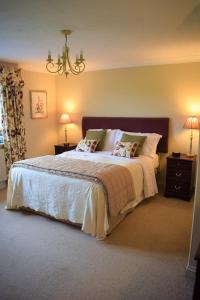 1 dormitorio con 1 cama grande con sábanas y almohadas blancas en Parc Yr Odyn, en Pentraeth