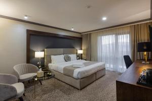 um quarto de hotel com uma cama grande e uma secretária em Jermuk Hotel and SPA em Jermuk