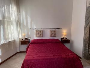 a bedroom with a white bedspread and a red bedspread at Ostello-Albergo dagli Elfi in Barrea