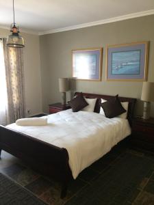 1 dormitorio con 1 cama grande con sábanas y almohadas blancas en Edi's B&B and Bratwurst Sausage Restaurant en Balgowan