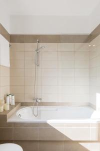 a bathroom with a bath tub with a shower at Villa White Stone by Rodostamo Collection in Kassiopi