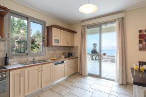 a kitchen with a view of the ocean at Villa White Stone by Rodostamo Collection in Kassiopi
