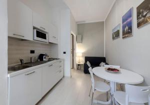 トリノにあるAPARTMENT LINGOTTO AP3の白いキッチン(白いテーブルと椅子付)