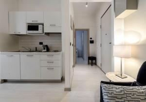 トリノにあるAPARTMENT LINGOTTO AP3の白いキャビネット付きのキッチン、リビングルーム