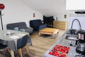 a kitchen and living room with a sink and a table at Résidences du Palmier in Saint-Laurent-sur-Sèvre