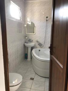 ein Badezimmer mit einer Badewanne, einem Waschbecken und einem WC in der Unterkunft Our house in Bordschomi